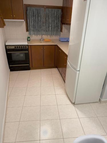 a kitchen with a white refrigerator and a tile floor at Anastasia's House Νιγρίτα near Serres in Nigríta