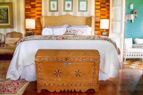 Schlafzimmer mit einem großen Bett und einem Holztisch in der Unterkunft Pousada Rabo do Lagarto in Pedra Azul