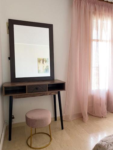 a mirror on a desk with a stool and a chair at Anastasia's House Νιγρίτα near Serres in Nigríta
