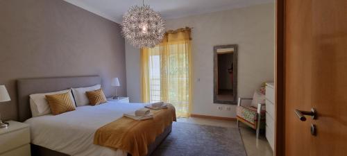 Un dormitorio con una cama grande y una lámpara de araña. en Encosta Da Orada Vista Mar, en Albufeira