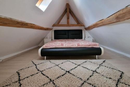 ein Schlafzimmer mit einem Bett im Dachgeschoss in der Unterkunft Maison dans un des plus beaux villages de Wallonie in Gesves