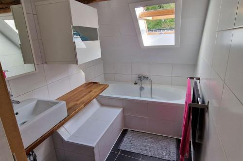 Baño blanco con bañera y lavamanos en Maison dans un des plus beaux villages de Wallonie en Gesves