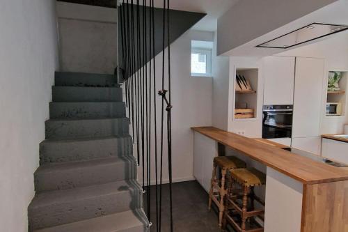 eine Treppe, die zu einer Küche mit einer Theke führt in der Unterkunft Maison dans un des plus beaux villages de Wallonie in Gesves