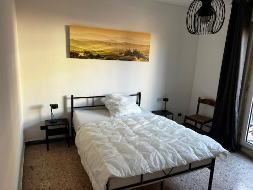 1 dormitorio con 1 cama y una pintura en la pared en Villa Model, en Buonabitacolo
