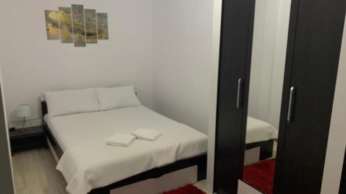 een kleine slaapkamer met een klein bed met schoenen erop bij Apartament in regim hotelier in Timişoara