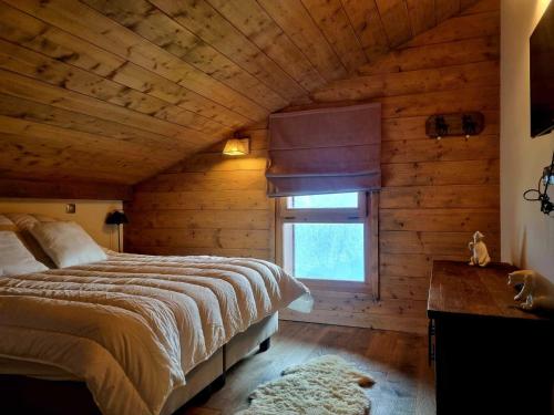 sypialnia z łóżkiem i oknem w drewnianym domku w obiekcie Appartement Les Saisies, 4 pièces, 8 personnes - FR-1-293-370 w mieście Hauteluce