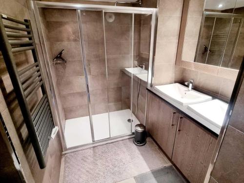 a bathroom with a shower and two sinks and a mirror at Appartement Les Saisies, 4 pièces, 8 personnes - FR-1-293-370 in Hauteluce