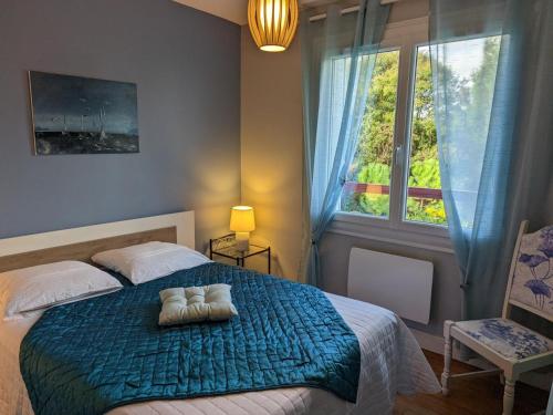 a bedroom with a bed with a blue blanket and a window at Appartement Barbezieux-Saint-Hilaire, 3 pièces, 4 personnes - FR-1-653-196 in Barbezieux-Saint-Hilaire