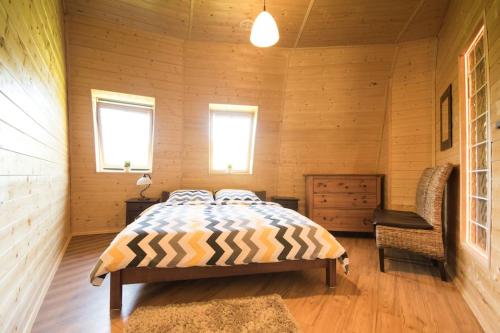 um quarto com uma cama e uma cadeira num quarto em Okrągły dom z bala Arena SPA sauna, jacuzzi! em Krąg