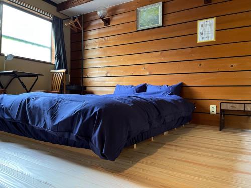 Cama en habitación con pared de madera en Yoshino-gun - House - Vacation STAY 61738v, en Kami-ichi