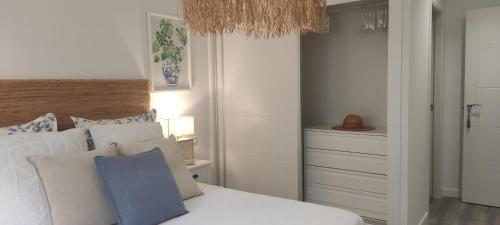 a bedroom with a bed with a blue pillow on it at Kentia golf Playa Granada in Motril