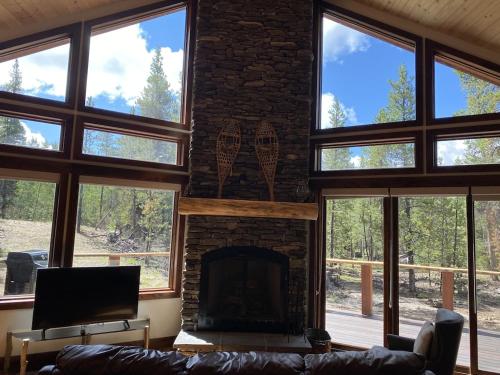 a living room with a brick fireplace and a couch at Family Friendly, Pet Friendly, New Build, 20 mi to Breckenridge - Lamplighter Lodge in Fairplay