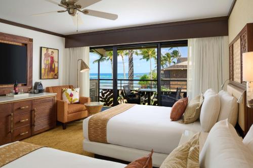 a bedroom with a bed and a view of the ocean at Koa Kea Resort on Poipu Beach in Koloa