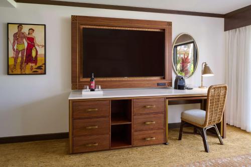 a desk with a television and a chair in a room at Koa Kea Resort on Poipu Beach in Koloa