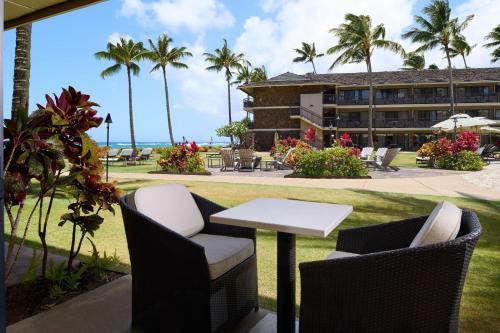 a table and chairs in front of a resort at Koa Kea Resort on Poipu Beach in Koloa