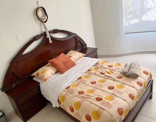 uma cama com uma cabeceira de madeira num quarto em Lindo y Céntrico MiniDepartamento I em Trujillo
