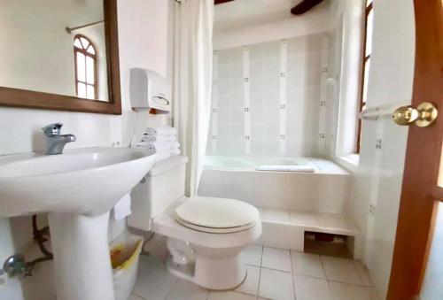 a bathroom with a toilet and a sink and a tub at INTIYAYA - Boutique Lodge in Otavalo