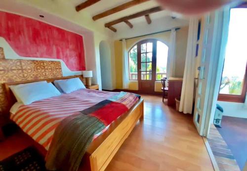 a bedroom with a large bed and a large window at INTIYAYA - Boutique Lodge in Otavalo