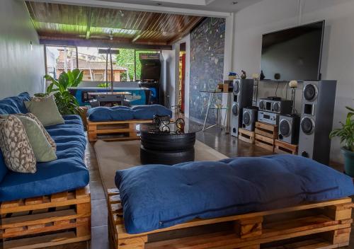 Habitación con 4 camas azules y TV. en Eco Stay Hostel en San José