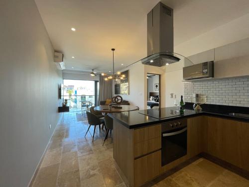 a kitchen with a counter and a dining room at New & Equipped Apartment Steps From The Beach With Pool Jacuzzi By Yeah in Playa del Carmen