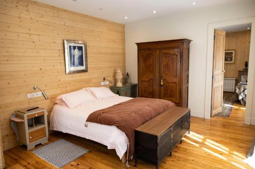 a bedroom with a large bed with a wooden wall at LE 41 AVENUE FOCH in Luchon