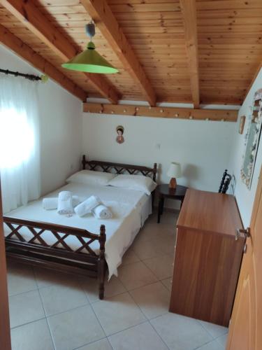 a bedroom with a bed and a wooden ceiling at Alpha apartment, Ireon Samos in Ireon