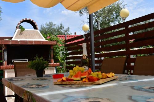 a plate of fruit on a table on a patio at VILLA IBIS THASSOS in Chrysi Ammoudia
