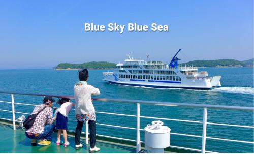 a group of people looking at a blue sky blue boat at Aoisora Aoiumi no guest house - Vacation STAY 74130v in Takamatsu