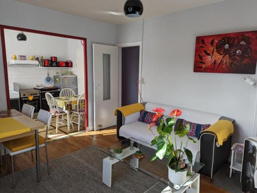 un salon avec un canapé et une table dans l'établissement Appartement cosy avec terrasse et jardin privatif, à 5 min du centre-ville de Barbezieux. - FR-1-653-196, à Barbezieux-Saint-Hilaire