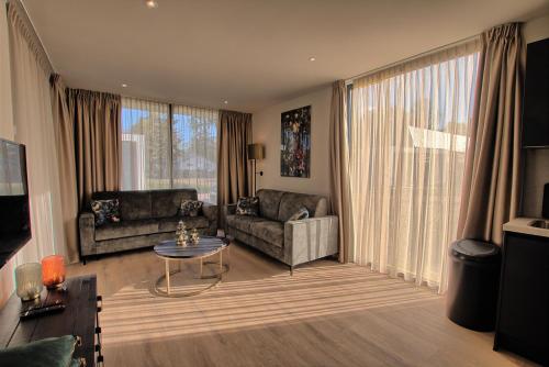 een woonkamer met een bank en een tafel bij Najade Resort Het Gooi in Eemnes