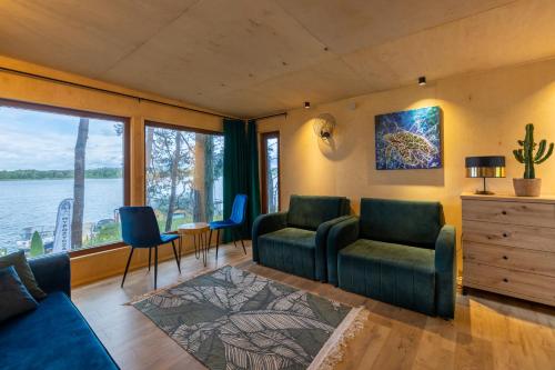 a living room with a view of the water at Nad Narvią - dom na drzewie in Serock