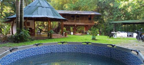 una piscina en un patio con una casa al fondo en casa en el parque tayrona, en Santa Marta