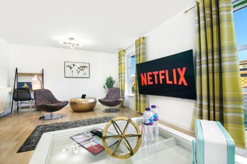una sala de estar con una señal de netflix en la pared en Bannermill Place Lodge ✪ Grampian Lettings Ltd en Aberdeen