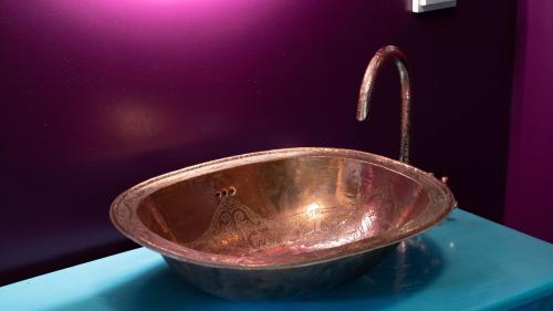 a copper bowl with a faucet on a table at Wonderland in Pieterburen