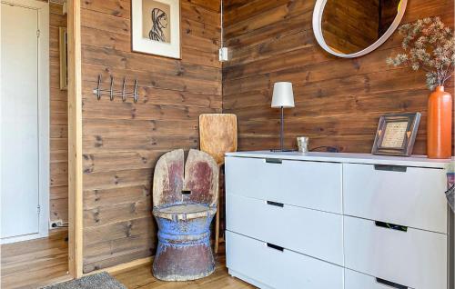 a bathroom with a wooden wall with a toilet in it at 3 Bedroom Awesome Home In Eggedal in Eggedal