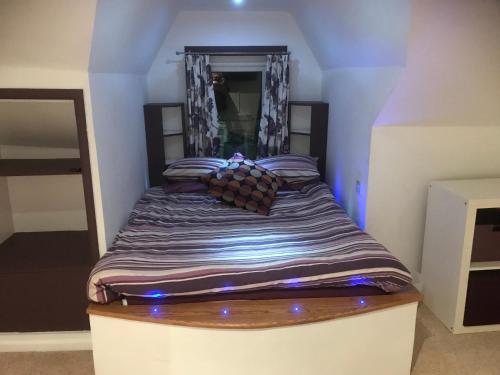 łóżko w pokoju z niebieskimi światłami w obiekcie Top floor in beautiful home w mieście Radipole