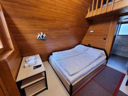 Dormitorio pequeño con cama y mesa en Koliba Umoljani en Umoljani