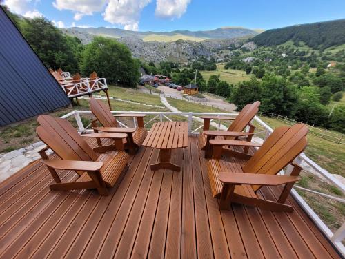 three chairs and a table on a deck with a view at Koliba Umoljani in Umoljani