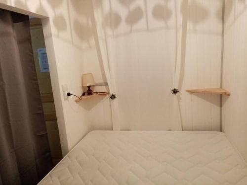 - une chambre avec un lit blanc et une porte avec une lampe dans l'établissement Appartement au cœur de la ville, à Ax-les-Thermes