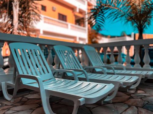 una fila de sillas azules sentadas en un balcón en Hotel Parque Atlântico, en Ubatuba