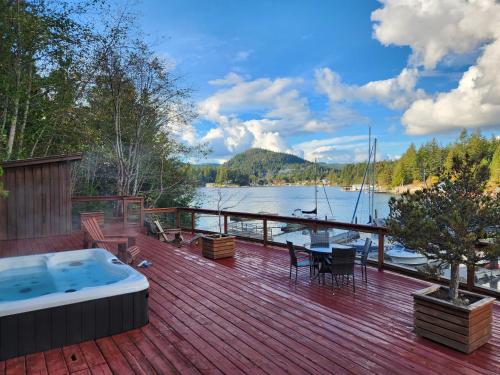 a deck with a hot tub and a table and chairs at Sunshine Coast Resort in Madeira Park