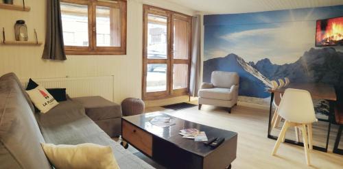 a living room with a couch and a giraffe mural at Appartement 6/7 personnes pied des pistes à Plagne centre in La Plagne
