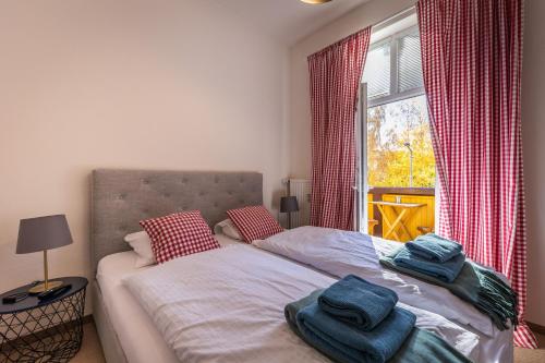 1 dormitorio con 1 cama con toallas en Vila Mudroň, en Dolný Smokovec