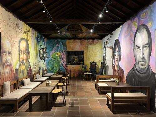 Zimmer mit Tischen und Gemälden an den Wänden in der Unterkunft Santa Helena Iscala in Chinácota