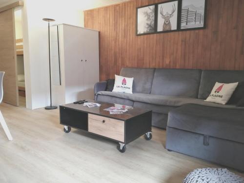 a living room with a couch and a coffee table at Appartement 6/7 personnes pied des pistes à Plagne centre in La Plagne
