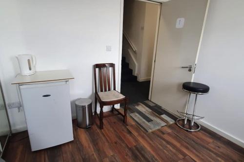 um quarto com uma cadeira, um balcão e uma porta em Spacious bedroom close to city centre em Sheffield