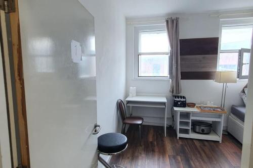 um pequeno quarto com uma secretária e uma janela em Spacious bedroom close to city centre em Sheffield