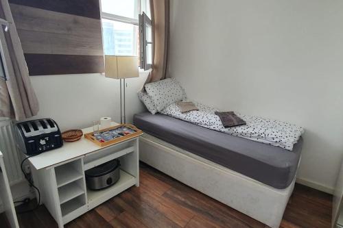 um pequeno quarto com uma cama e uma mesa em Spacious bedroom close to city centre em Sheffield