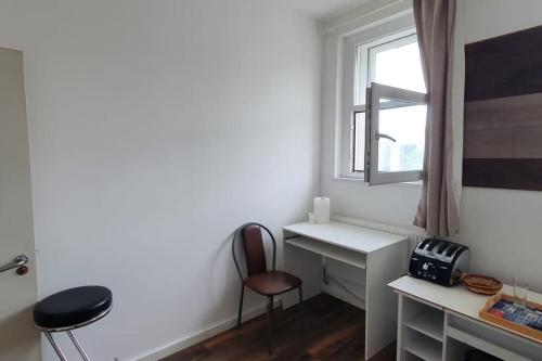 um quarto com uma secretária, uma cadeira e uma janela em Spacious bedroom close to city centre em Sheffield