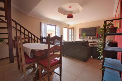 a living room with a table and a couch at Suites Palmeiras Cabo Frio in Cabo Frio